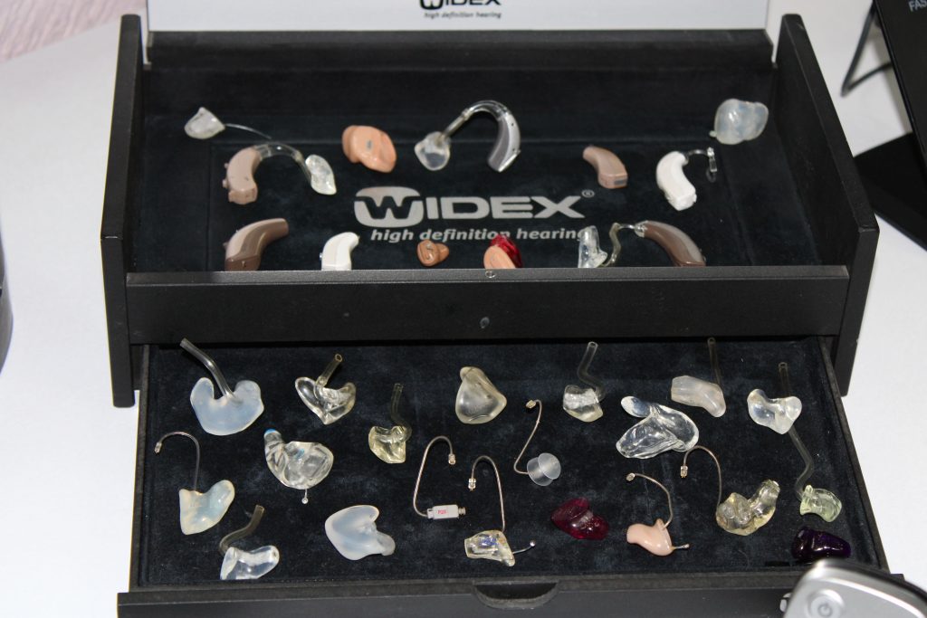 Exhibidor Widex con distintos modelos de auxiliares auditivos y moldes a la medida
